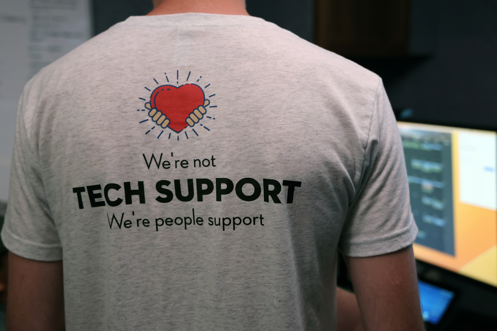 A 1to1 Technologies’ employee wears a shirt with the company’s tagline, "We're not tech support; we're people support," on the back. Photo by Russell Shaffer