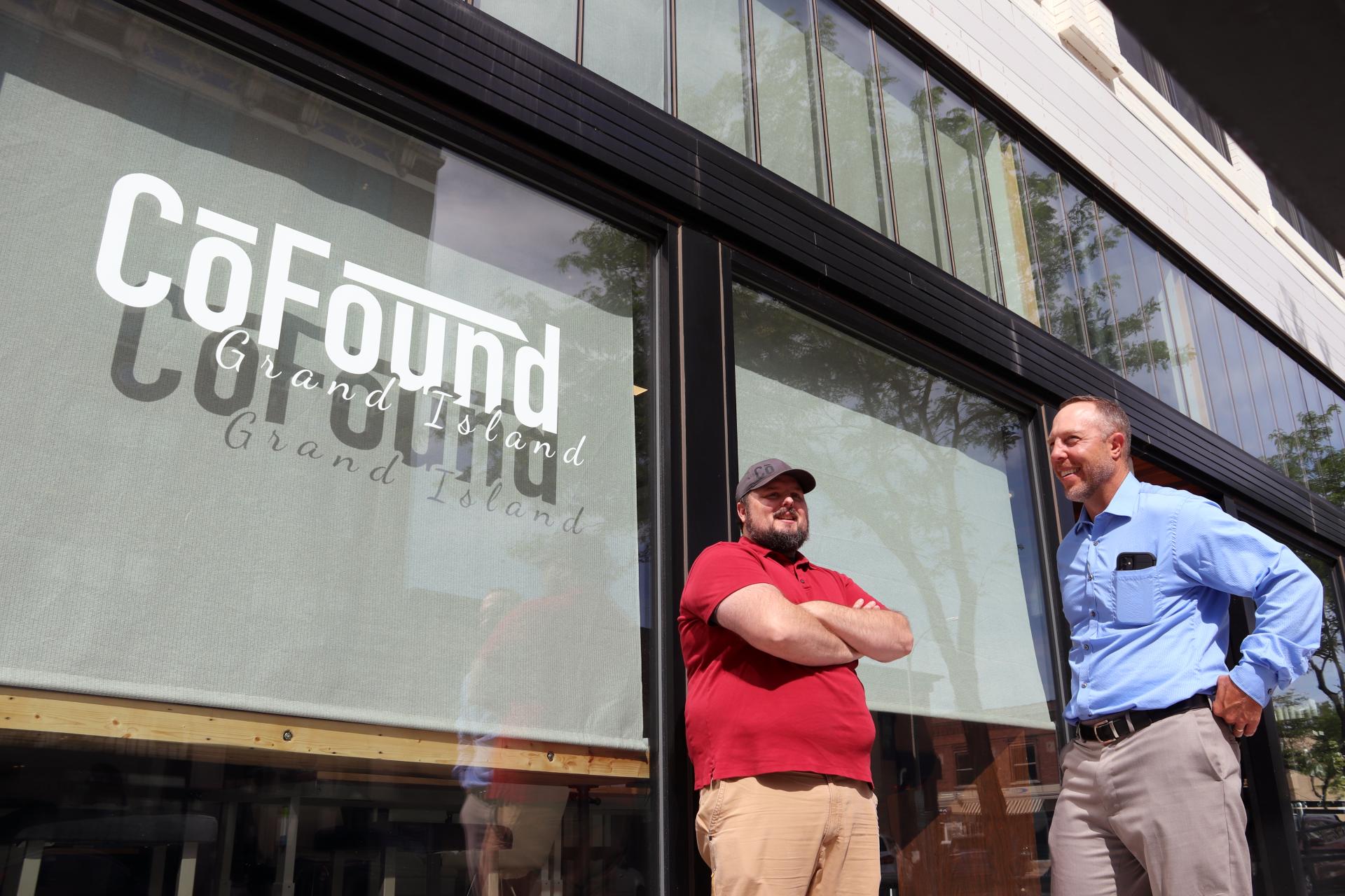 two men gather outside of newly opened store.
