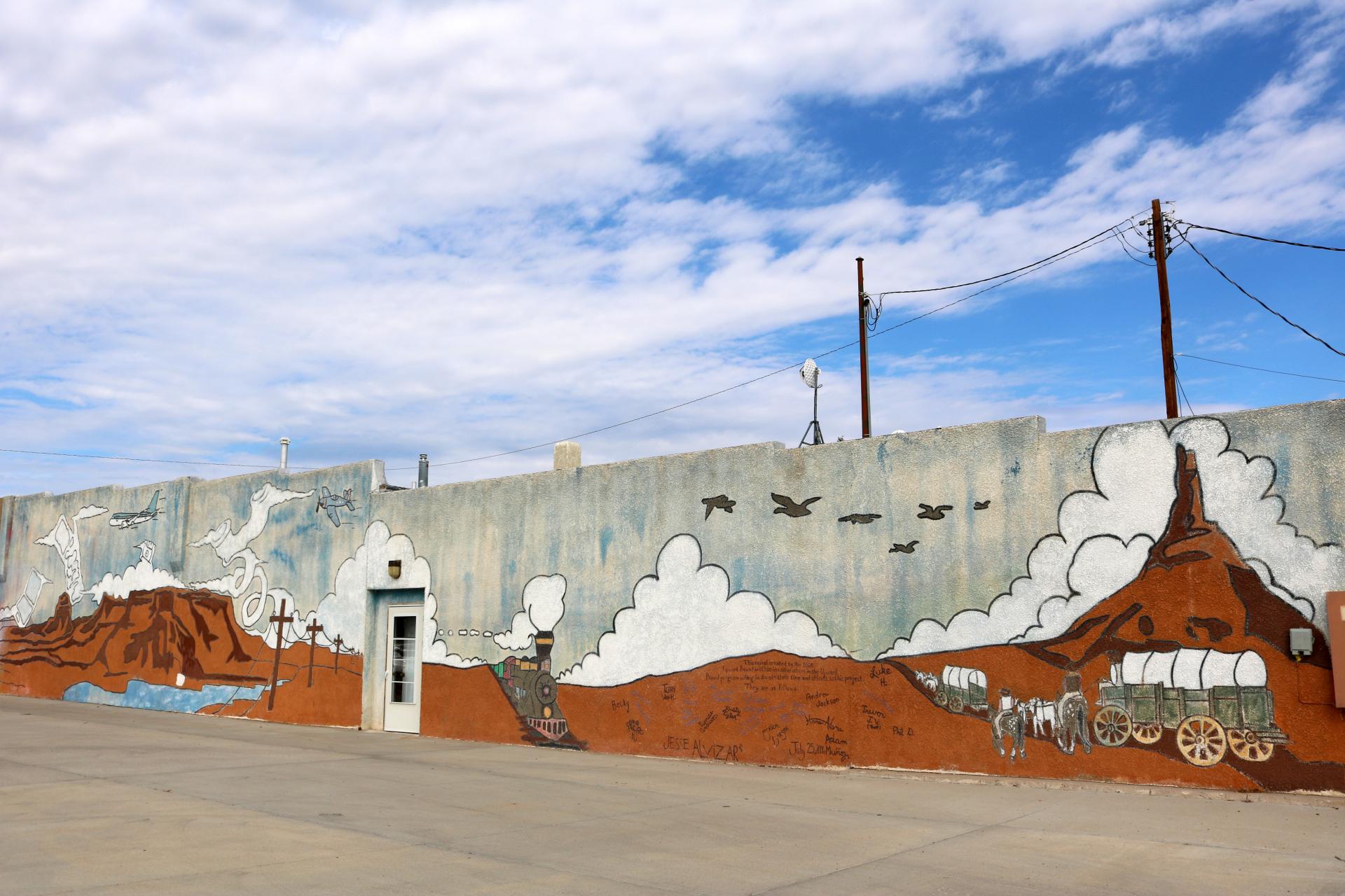 Designed and painted in 2008 by students in Scottsbluff’s Upward Bound program, this mural depicts the evolution of communication and transportation in Scotts Bluff County.