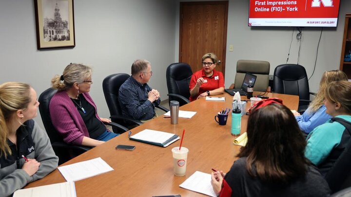 A group of people have a discussion around a conference table.