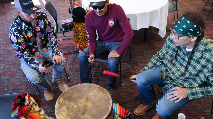 Kenny Harnage (seated, from left), Daniel Laravie and Nathaniel Laravie play a traditional Native honor song at the Hoop of Learning kickoff event.