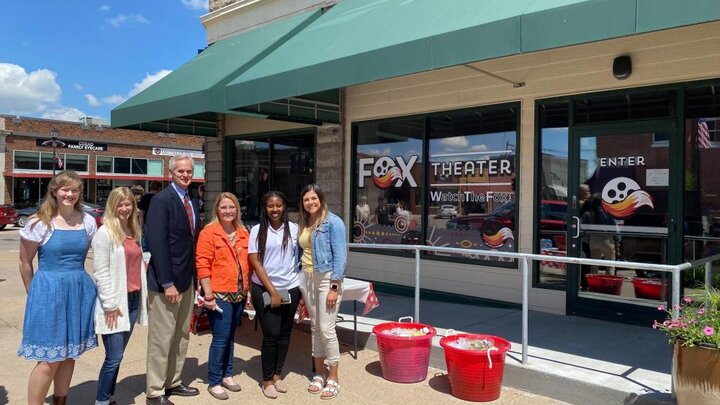 Rural Fellows Alicia Pannell (left), Tori Pedersen (second from left) and Janet Kabetesi (fifth from left) and community fellows Andrea McClintic (fourth from left) and Stephanie Novoa (right) are pictured with Lt. Gov. Mike Foley (third from left) at the Fox Theater ribbon cutting in Cozad.