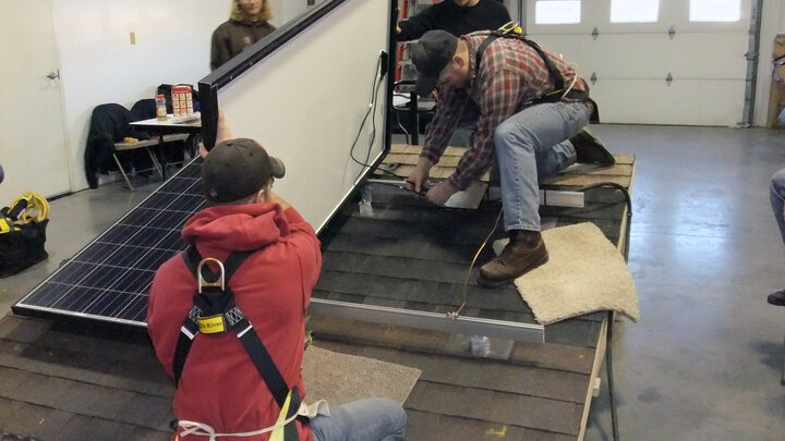 Workshop attendees practice building and installing solar panels.