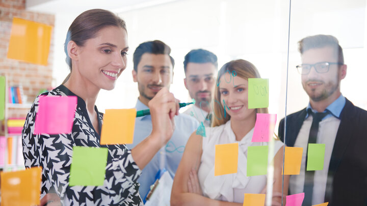 Stock photo of office workers and colorful papers.