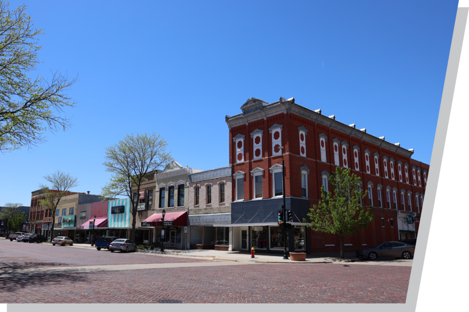 Small buildings on a rural community downtown with red brick streets.